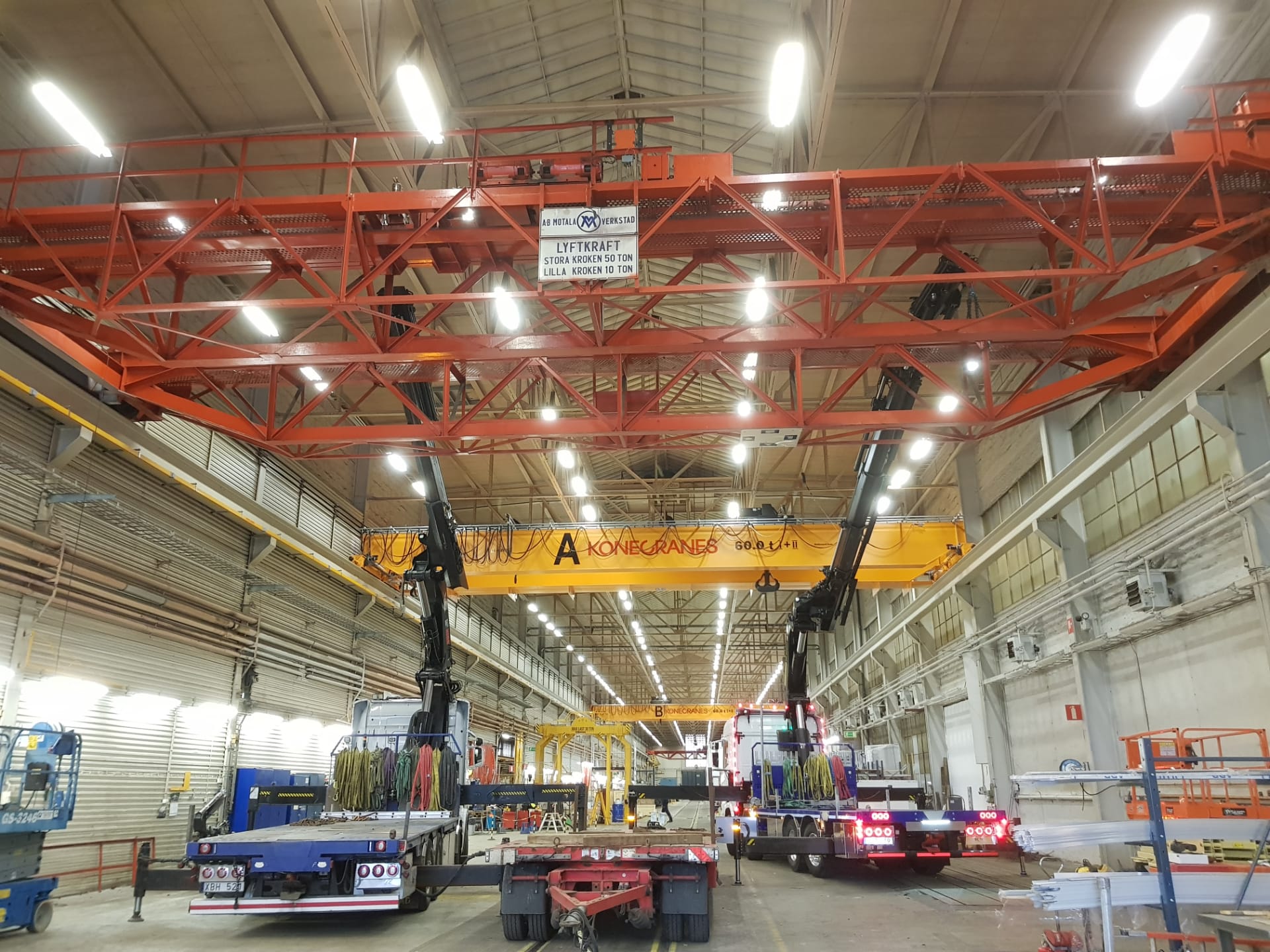 Axfalks montörer på skylift lyfter en traversbalk på plats i en industrihall i Linköping