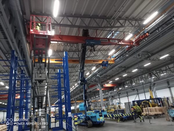 Dubbelbalkstravers på kranbana med nedsänkt lyftblock i industrihall